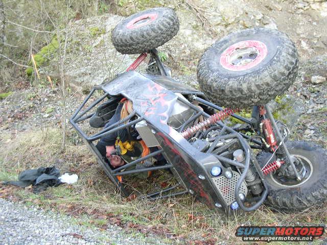 Rolled-over off-road buggy with large tires and roll cage