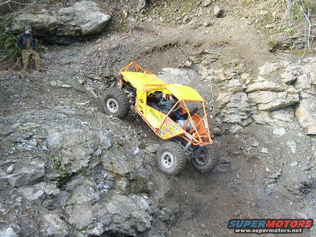 Yellow off-road buggy climbing a rocky hill