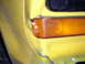 1978 Ford Bronco - Close-up of a yellow vehicle's fender and amber marker light, with a Supermotors.net logo in the corner.