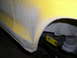 1978 Ford Bronco - Detail shot of a yellow vehicle's fender and suspension, showing primer and some wear.