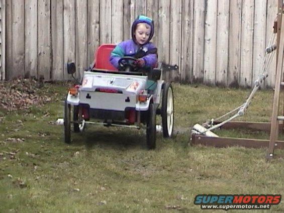 Toy car with a child driving, viewed from the rear