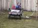1985 Ford F-150 - A child sits in a toy vehicle, steering it on a grassy lawn.