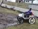 1985 Ford F-150 - A child drives a toy jeep through a muddy area in a backyard.