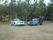 1999 Ford Mustang - Two 1999 Ford Mustangs are parked side-by-side in a field.