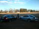 1999 Ford Mustang - Two 1999 Ford Mustangs are parked in a grassy field under a partly cloudy sky.