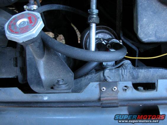 Radiator cap with red lettering and engine hoses