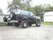 1995 Ford Bronco - A lifted black and tan Ford Bronco with flame decals is parked next to another vehicle.