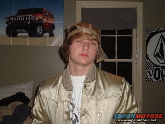 Poster of a red Hummer H2 on a wall behind a person wearing a hat and jacket