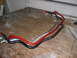1985 Ford Crown Victoria LTD - Three automotive sway bars are laid out on a workbench, with a watermark indicating the source as Supermotors.net.