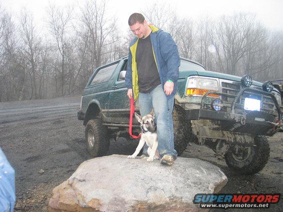 Green 1993 Ford Bronco parked off-road with a man holding a dog's leash