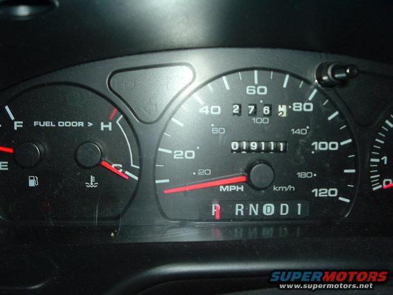 Car dashboard with speedometer, fuel gauge, and temperature gauge. Odometer shows 019111