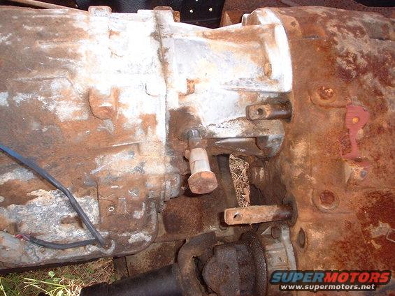Close-up of a heavily rusted transmission housing with some wiring