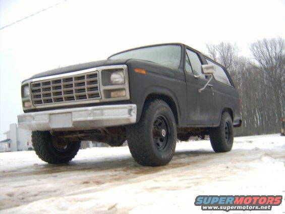 Dark gray SUV front 3/4 view in snow. Chrome grille and bumper