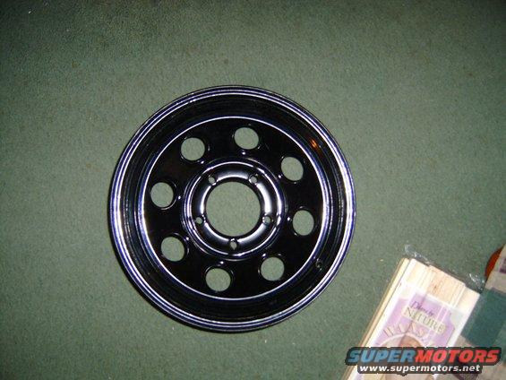 Black wheel with chrome trim and ten circular cutouts