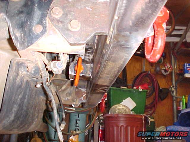 close-up of vehicle frame with red tow hook attached
