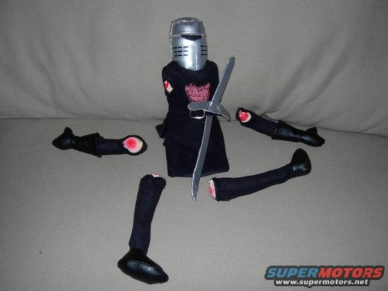 Knight toy with helmet, sword, and detached limbs scattered around it