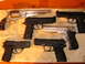 2002 Ford Taurus - A variety of firearms are displayed on a textured surface.