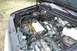 1988 Ford Bronco - The engine bay of a vehicle is shown, various hoses, wires, and a battery. A watermark for SUPERMOTORS is visible.