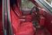 1988 Ford Bronco - The interior of a van features maroon velour seats and matching upholstery.