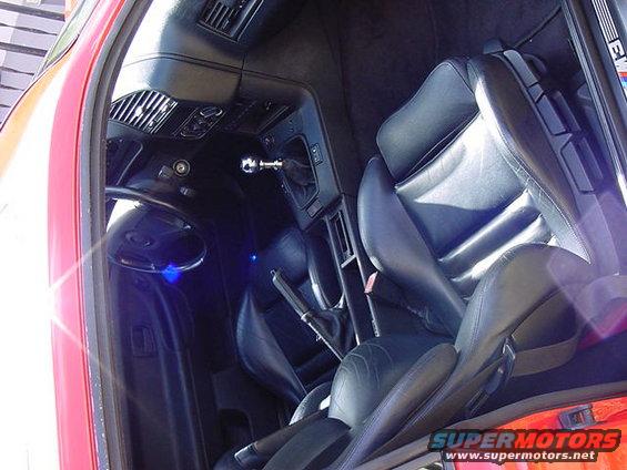 Interior of a 1995 BMW M3 showing black leather seats, dashboard, and gear shifter