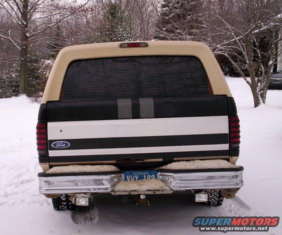 Tan and black Ford Bronco rear view in snow, with chrome bumper and Michigan license plate