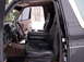 1993 Ford Bronco - The interior of the vehicle shows plush leather seats and a large center console with cup holders.