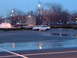 1995 Mercury Grand Marquis - A white sedan sits in a wet parking lot as dusk settles, with streetlights illuminating the scene.