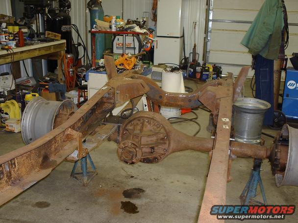 1978 Ford F-350 frame on jack stands, showing rusty axles and one wheel