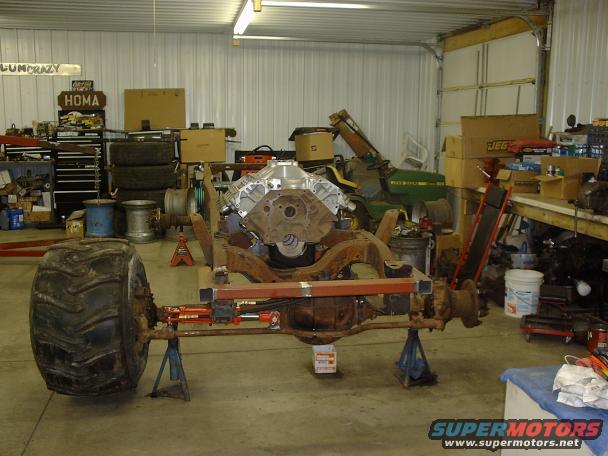 Truck chassis on stands with engine and large front tire
