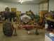 1978 Ford F-350 - A truck chassis, likely undergoing restoration or modification, is supported by stands in a workshop setting, with a large engine and a mas…