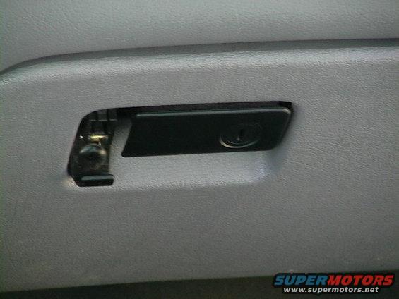 Close-up of a car's glove box latch mechanism
