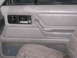 1991 Ford Bronco - Close-up of a vehicle's interior door panel, showing the handle, lock controls, and part of the seat.