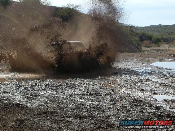 SUV splashing through a mud puddle off-road