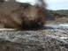 1993 Ford Bronco - An SUV navigates a muddy terrain, creating a large spray of mud.