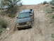 1993 Ford Bronco - A dark gray Ford Ranger navigates a steep, dusty off-road trail.