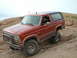 1993 Ford Bronco - This red Ford Bronco with a black top navigates a rocky off-road trail.