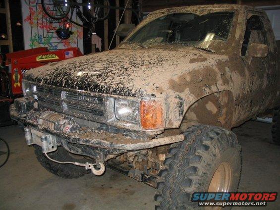 Mud-covered Toyota truck, front 3/4 view. Visible Toyota badge