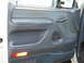 1992 Ford Bronco - The interior door panel of a vehicle shows the window controls, door handle, and a small amber light.
