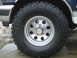 1992 Ford Bronco - Close-up of a Mickey Thompson Baja Claw Radial tire on a silver 5-hole wheel.