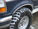 1992 Ford Bronco - Close-up of a 1992 Ford Bronco XLT's front tire and fender, showing snow accumulation.