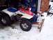 1987 Ford Bronco - A Honda FourTrax ATV is equipped with a rudimentary wooden snowplow, ready for winter conditions.
