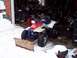 1987 Ford Bronco - ATV with a plow attachment sits in a garage during winter.