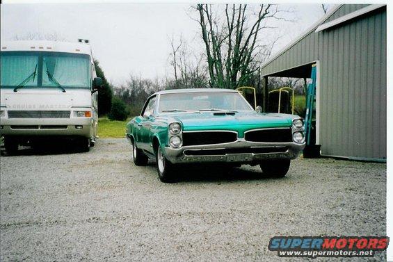 Green 1967 Pontiac Lemans front view parked next to an RV