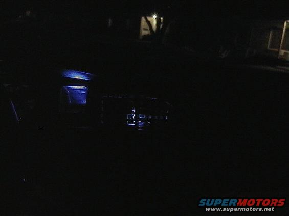 car interior with blue illuminated dashboard elements at night