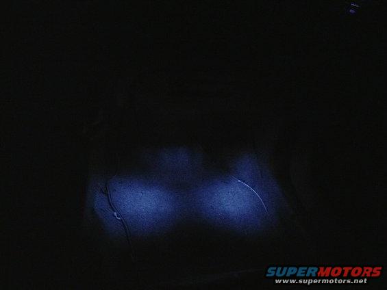 Dark interior with two illuminated blue lights and a wire
