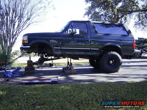 Dark green 1995 Ford Bronco on jack stands with front suspension removed