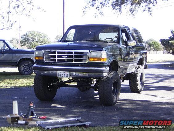 Lifted 1995 Ford Bronco, 3q-front view, dark blue with aftermarket wheels