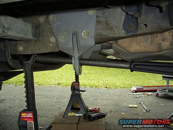 underbody of vehicle on jack stands, showing suspension parts and frame