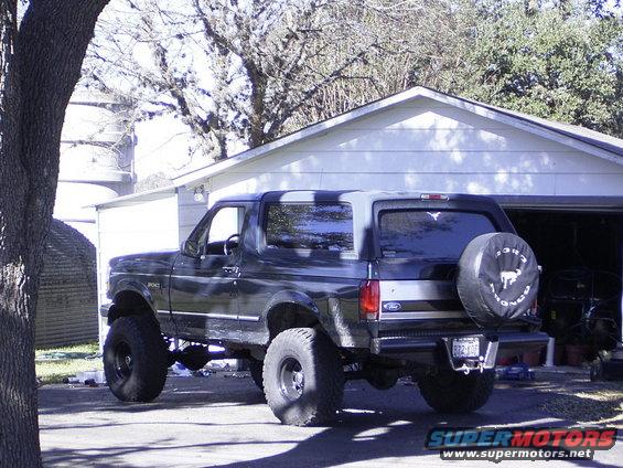 1995 Ford Bronco lifted with large tires, parked in driveway