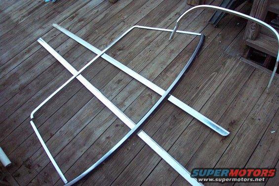 Chrome trim pieces laid out on a wooden deck